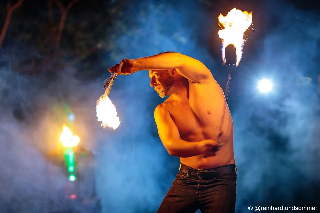 Feuerkünstler mit Fackeln im blauen Nebel