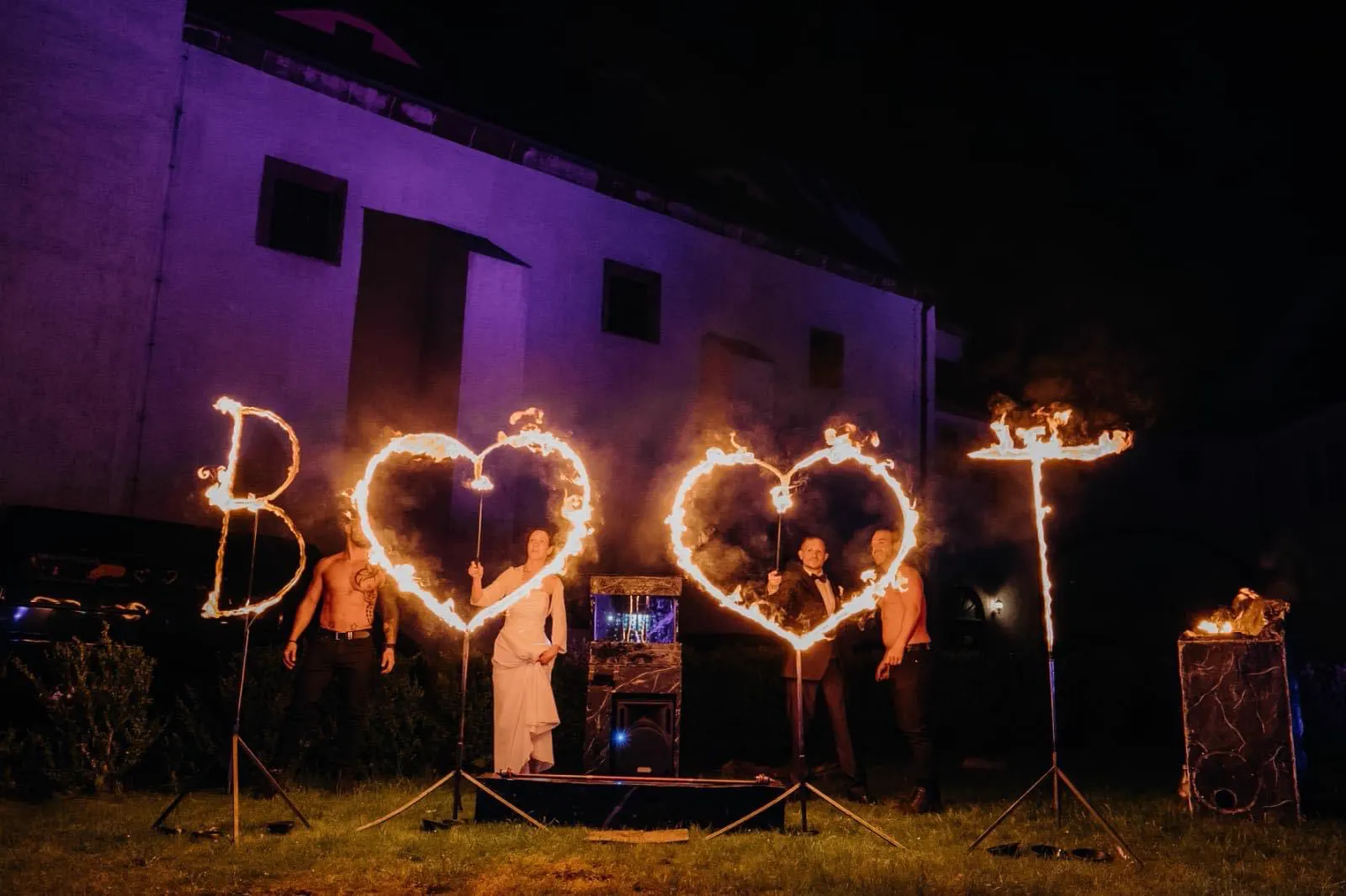 Brennende Initialen und zwei Flammenherzen bei Nacht