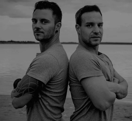 Björn und Joey, die Feuerkünstler der Hochzeitsfeuershow, Rücken an Rücken am Wasser